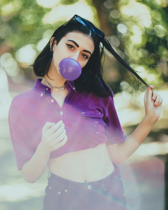 a woman holding a balloon over her face