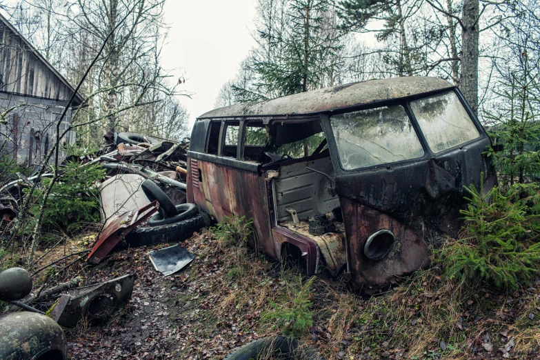 the old abandoned vehicle is sitting in a clearing