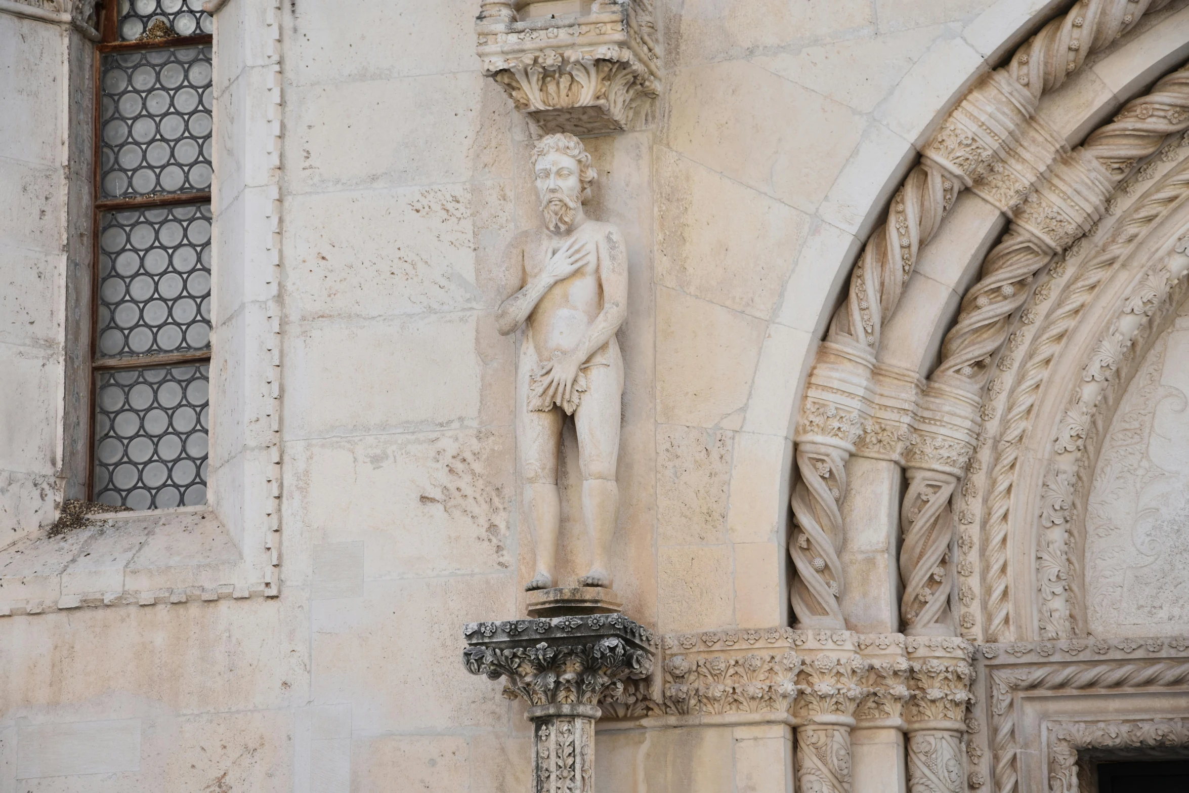 a statue standing next to an arched door