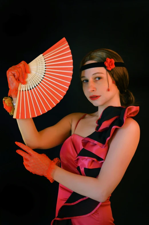 woman in pink and black dress holding an orange oriental parasol