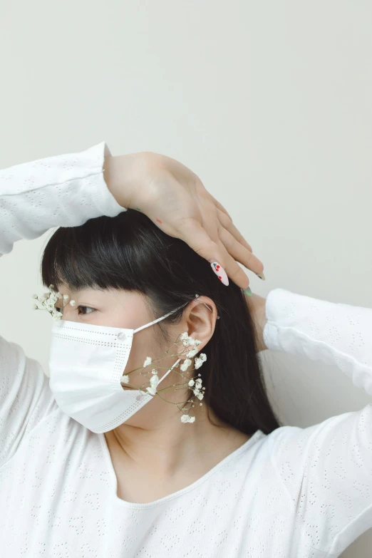 a woman wearing a surgical mask has her hair in a ponytail