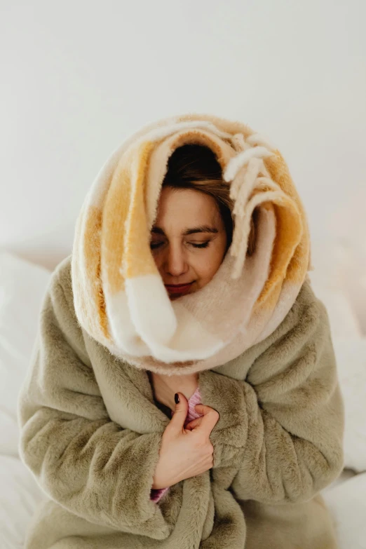 woman wrapped in blankets holding hair comb