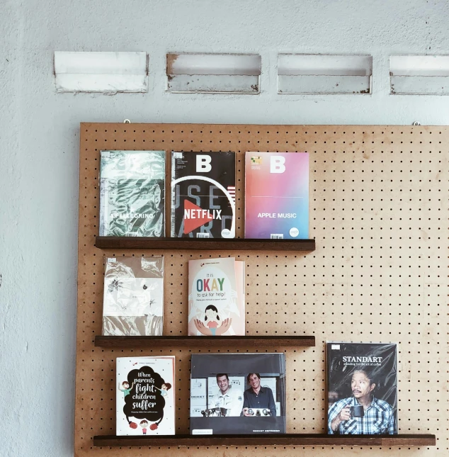 there are a couple books on the wall behind the shelf