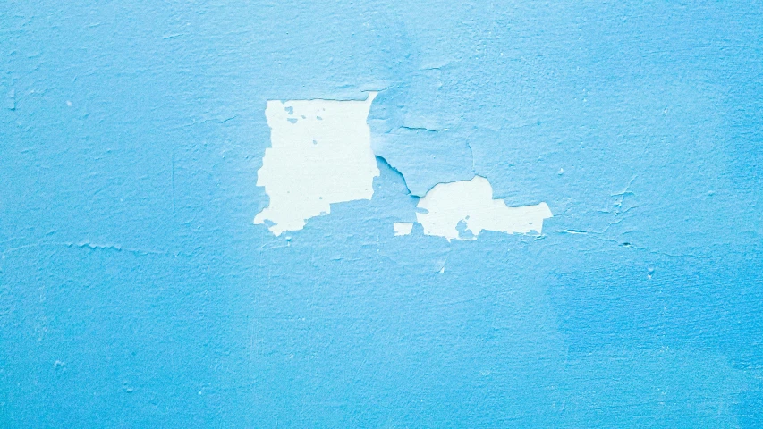 a close up of a painted blue wall with white paint
