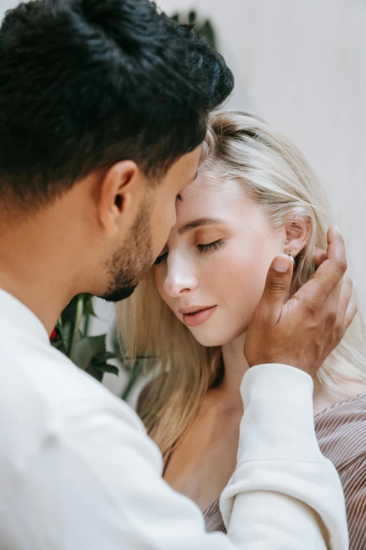 a man putting on the ear of his young lady