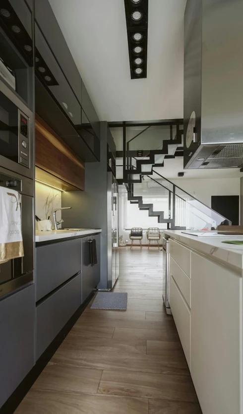 kitchen with stainless steel refrigerators and glass doors, modern staircase and skylight