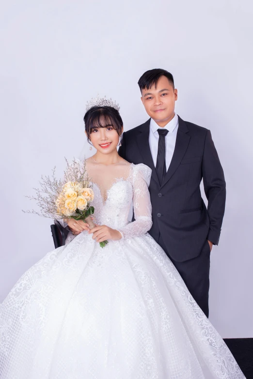 a woman in a white dress poses with a man wearing a suit