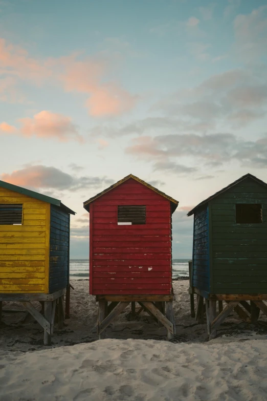 five small beach huts sit on top of the sand