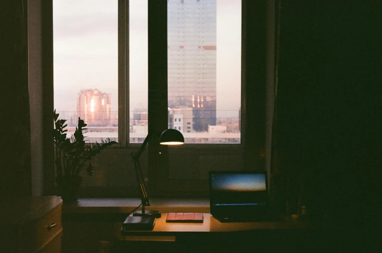 an office with a large window and a table by it