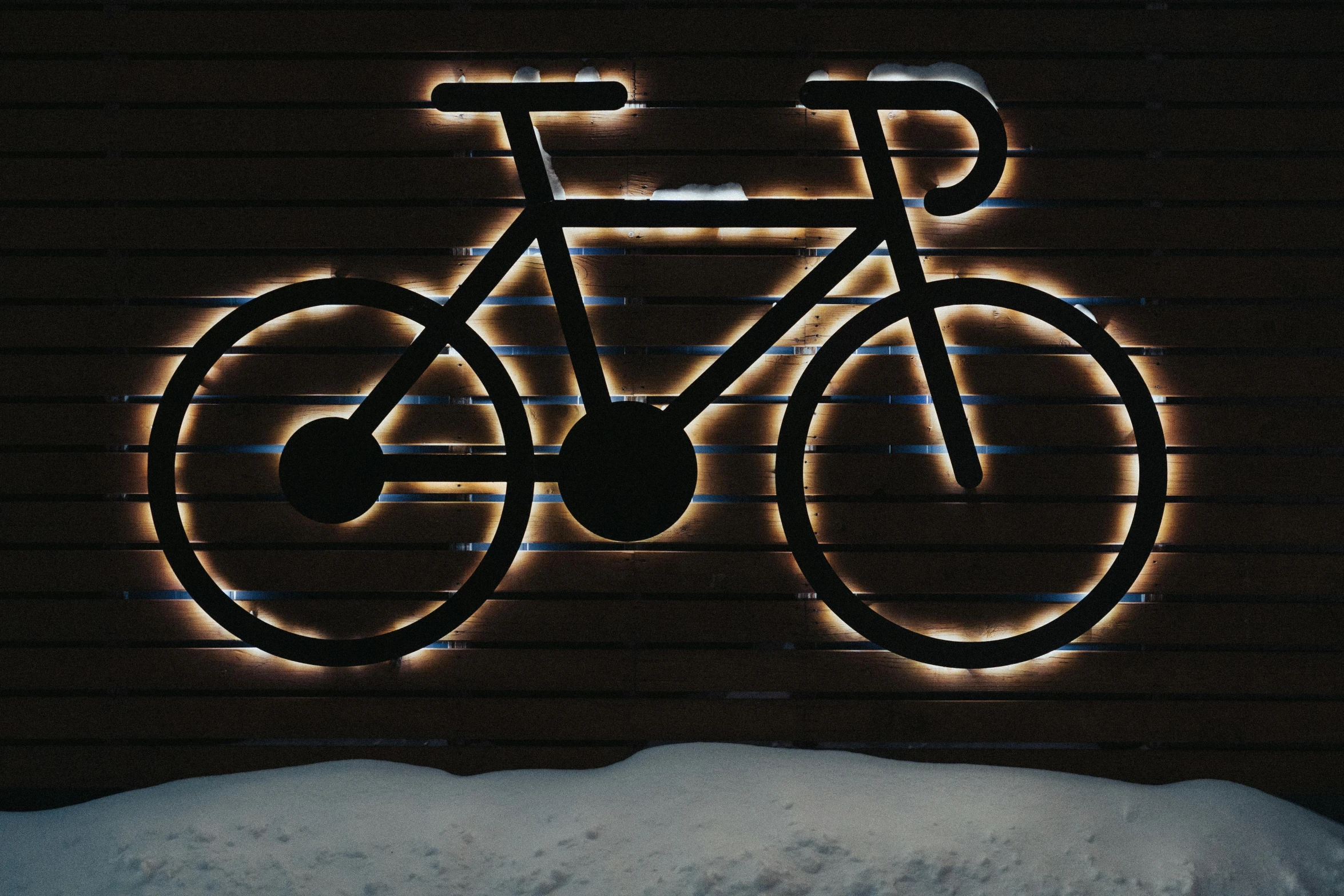 a lighted sign for a bike shop at night