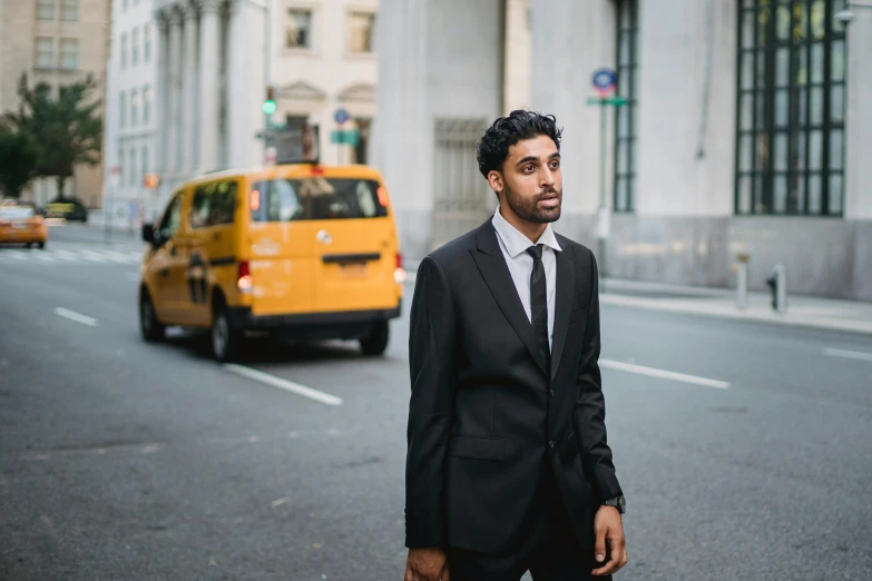 a man in a suit and tie standing in the middle of the street