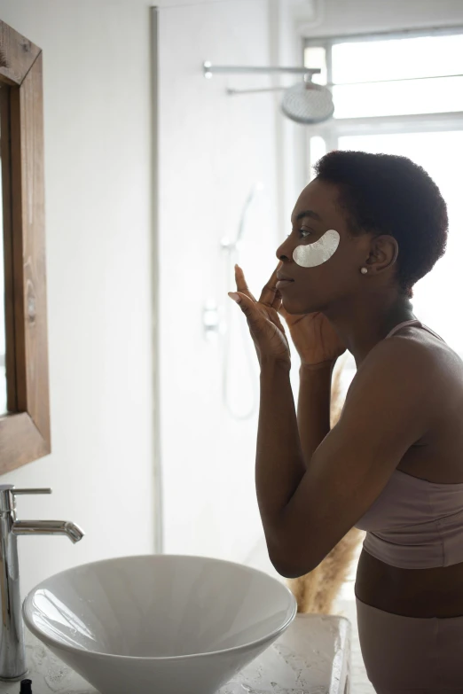 a woman standing in a bathroom brushing her teeth