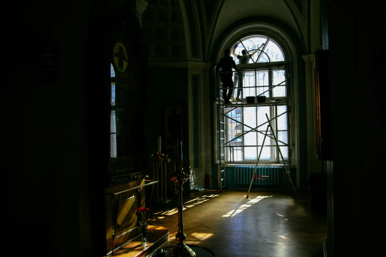 a person on a scaffold is leaning against the window