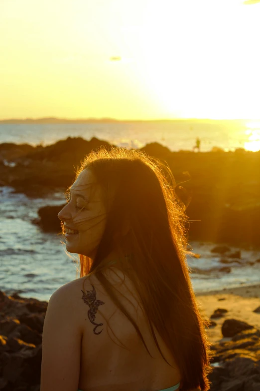 a girl with face paint standing on the beach