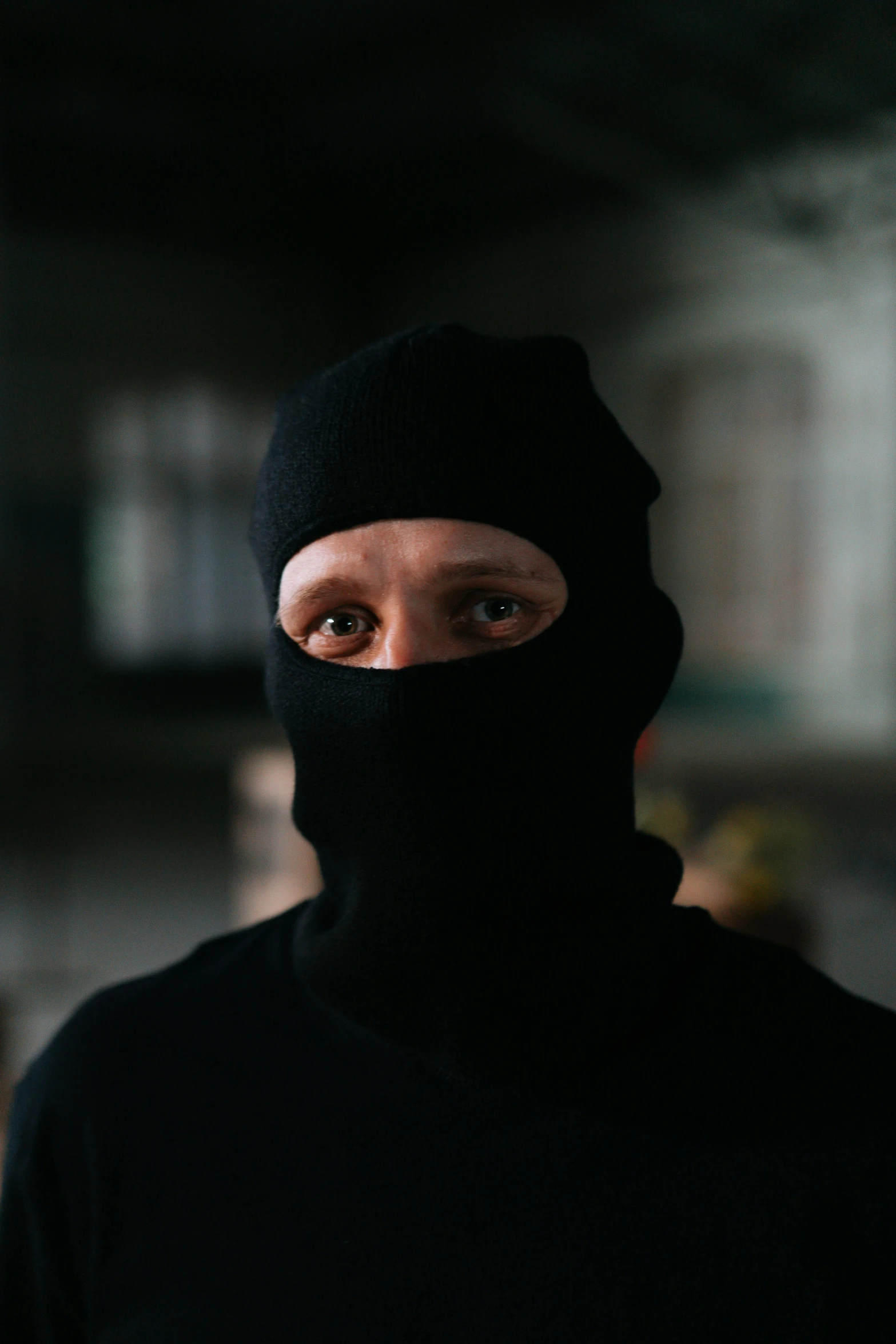 a man wearing a black hood and a black mask