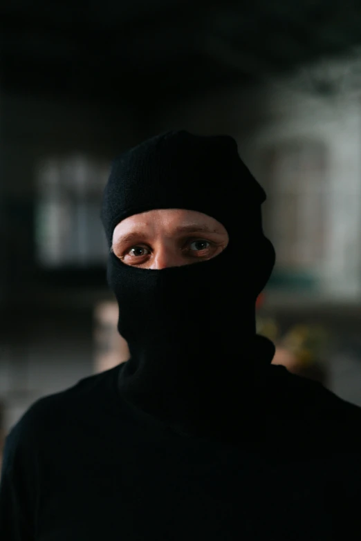 a man wearing a black hood and a black mask