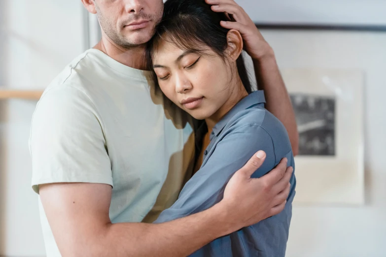 a man and woman hug while she holds the mans hair