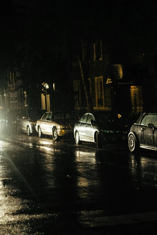 three cars on a dark city street at night