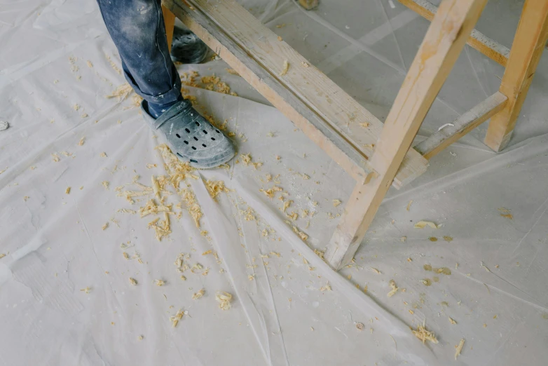 a person is sanding over a table in an unfinished room