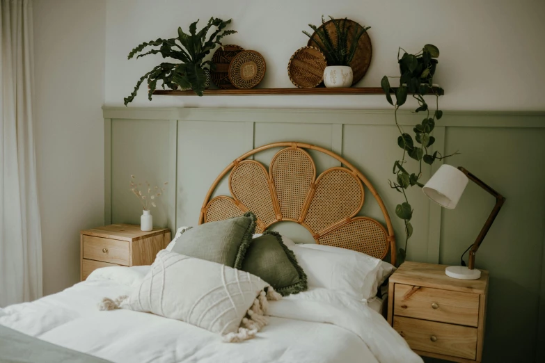 an unmade bed with white linens and wicker head board