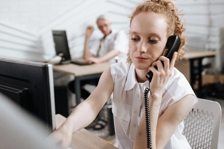 the woman is talking on her cell phone in an office