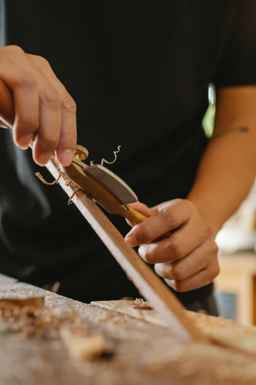 a person using a knife to cut a piece of wood