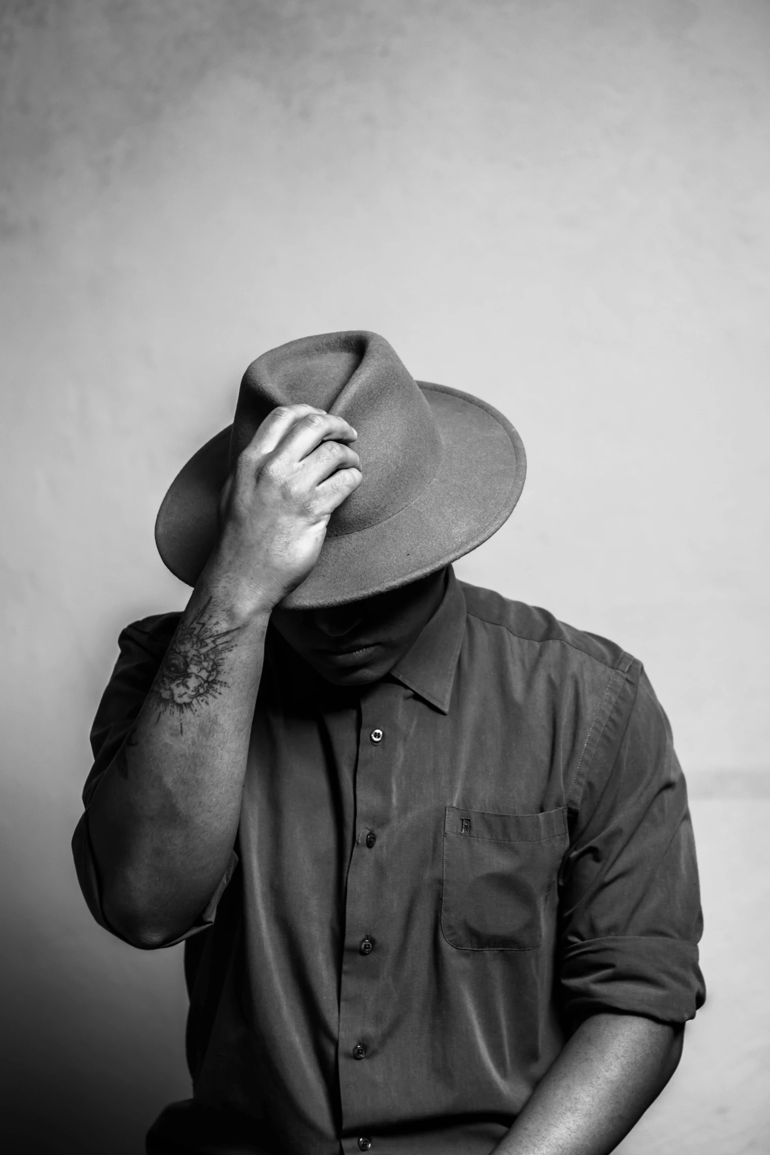 a man with his hand on his forehead while wearing a hat