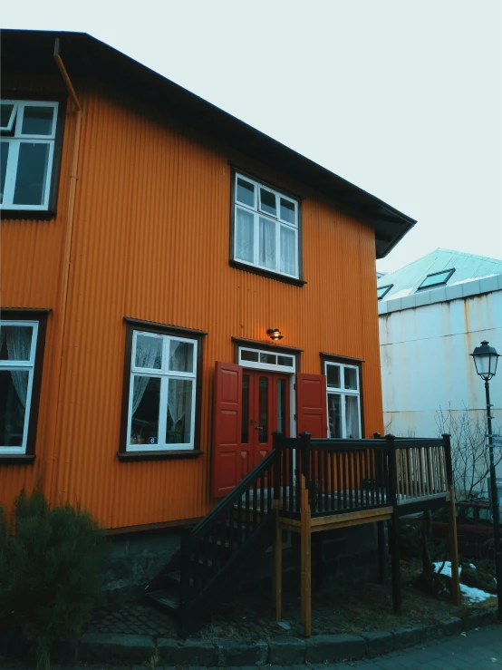 a large orange house with a porch and stairs