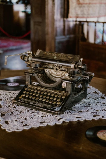 an old fashioned antique typewriter sits on lace