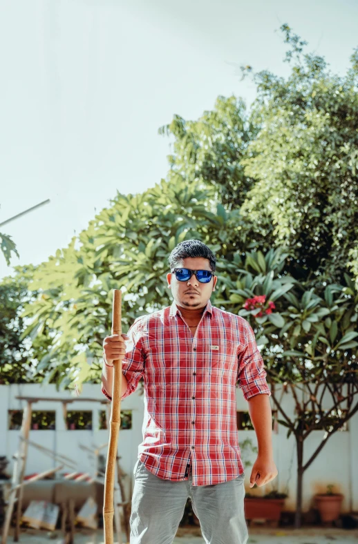 a man holding a baseball bat in a red shirt