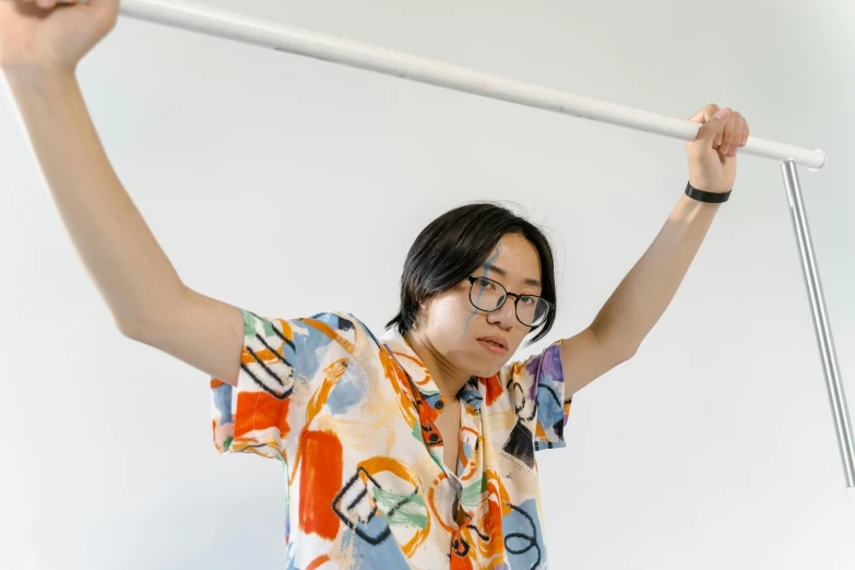 a woman wearing glasses holding up a white pole