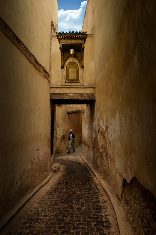 two people walking down an alleyway between two buildings