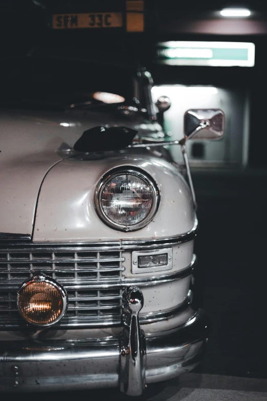 the front of a classic car parked at a gas station