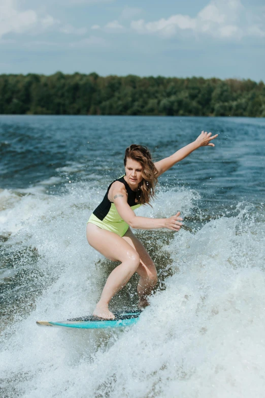 a woman in yellow shorts riding on a surfboard