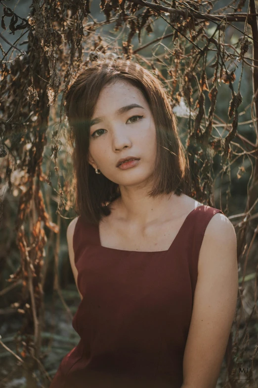 a woman is standing by a tree while looking at soing