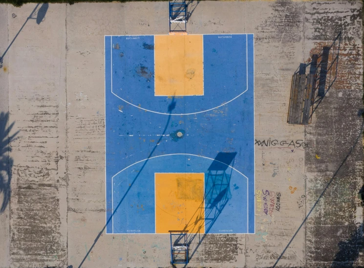 an overhead view of a basketball court, with the basketball court painted yellow