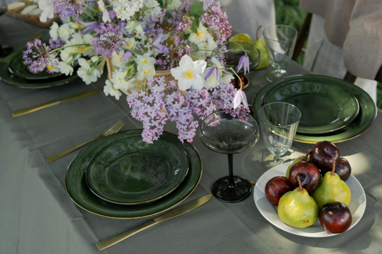 a table setting with flowers and green plates