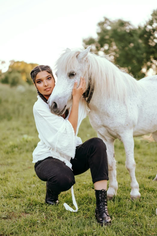 a woman is petting a horse on a field