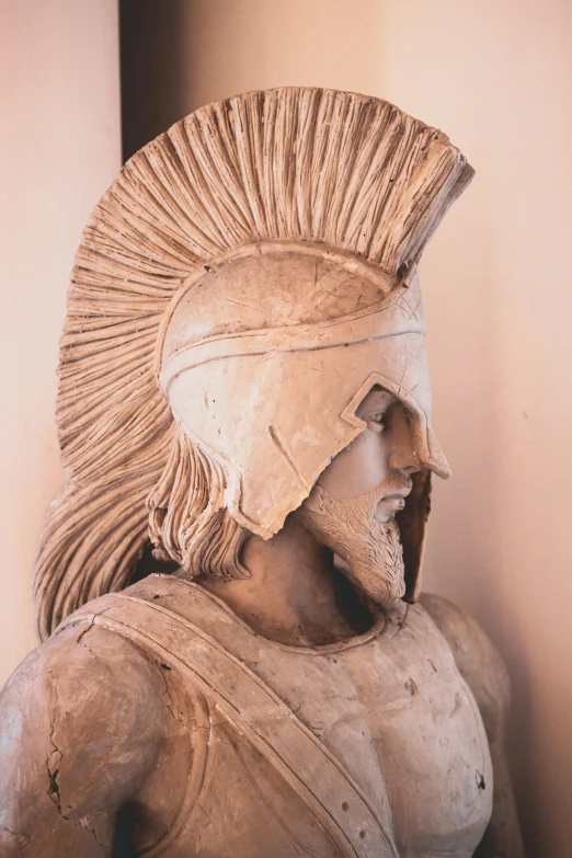 an ancient statue of a warrior wearing a helmet