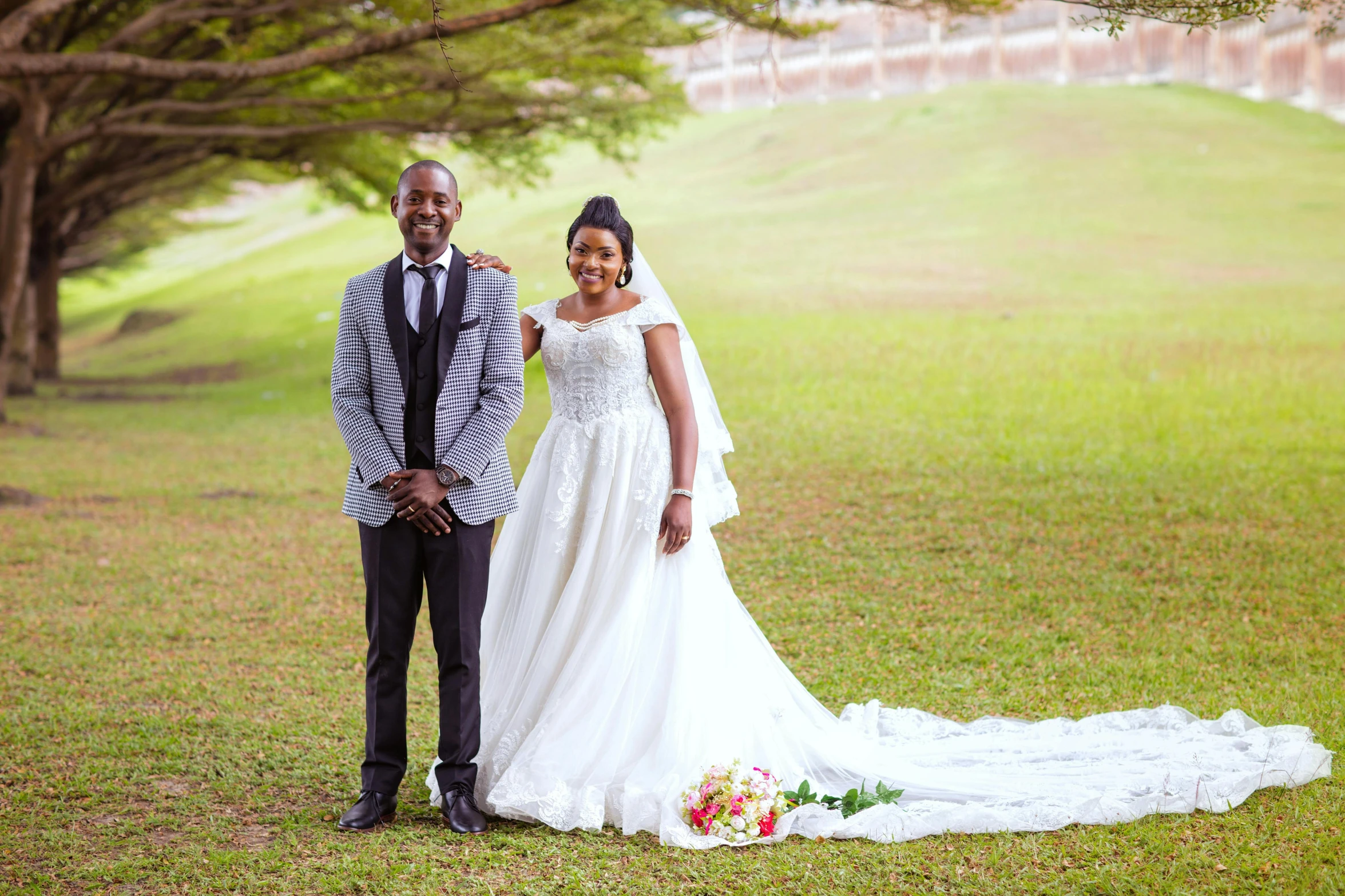 a bride and groom posing for a pograph outside