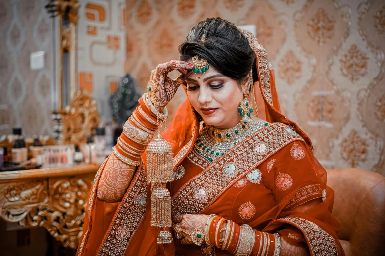 a woman with long dark hair and a wedding veil is looking at her jewelry