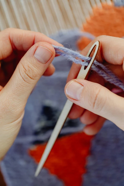 person making a purple ball of yarn from yarnstrew