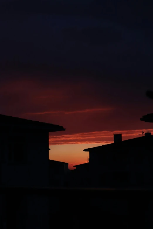 the view of the dark night sky and silhouettes of houses