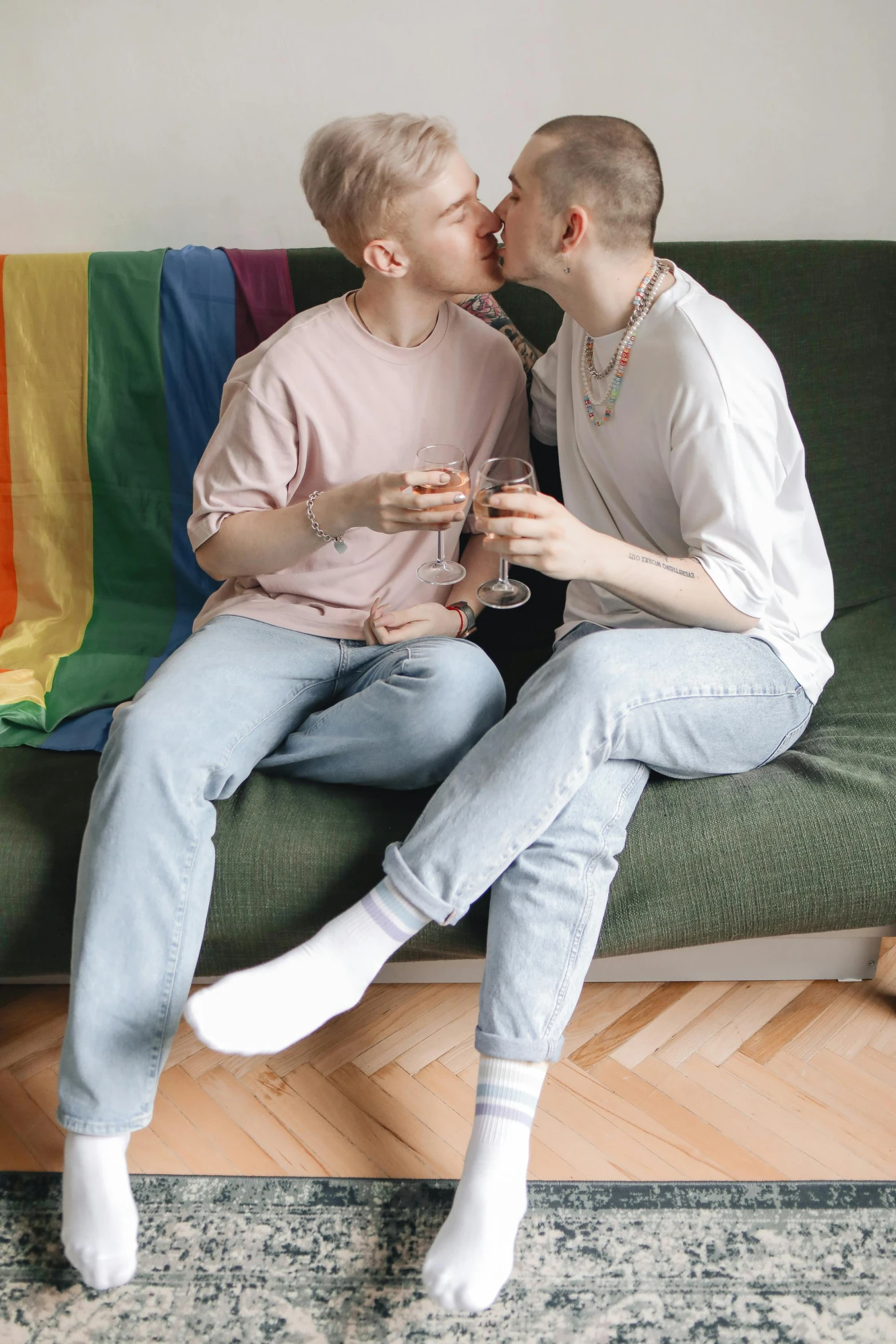 two people sitting on top of a couch and kissing