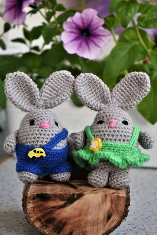 two small knitted animals with green and blue flowers