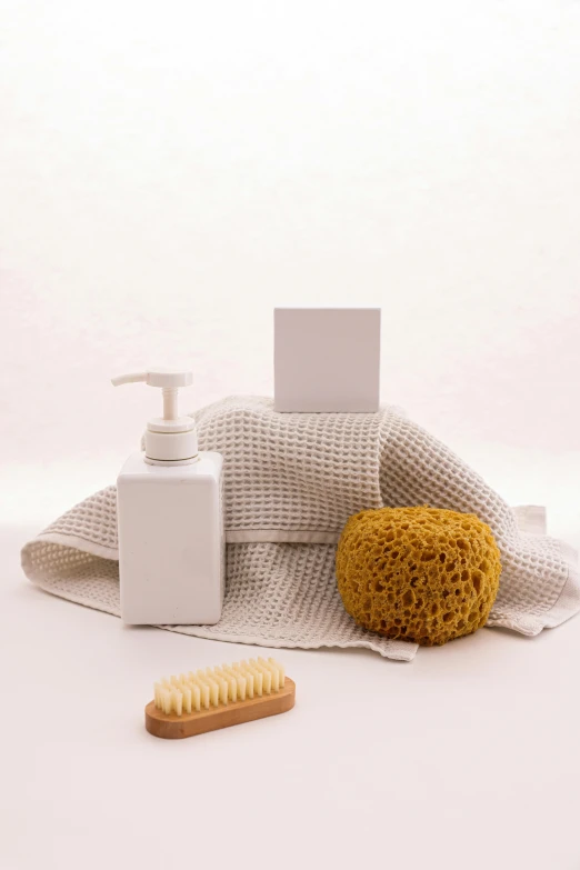 a white bag with a yellow comb next to a bottle of lotion and a brush