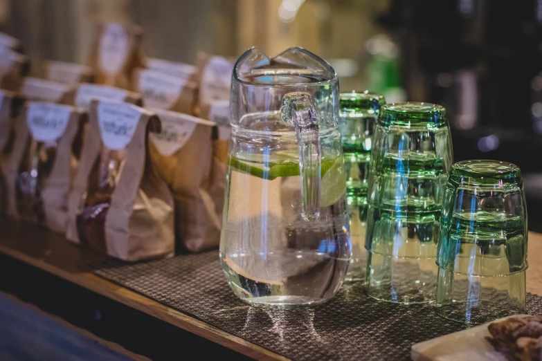 a row of bags filled with liquid in front of a large pitcher