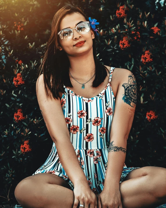 a  wearing glasses in front of some trees