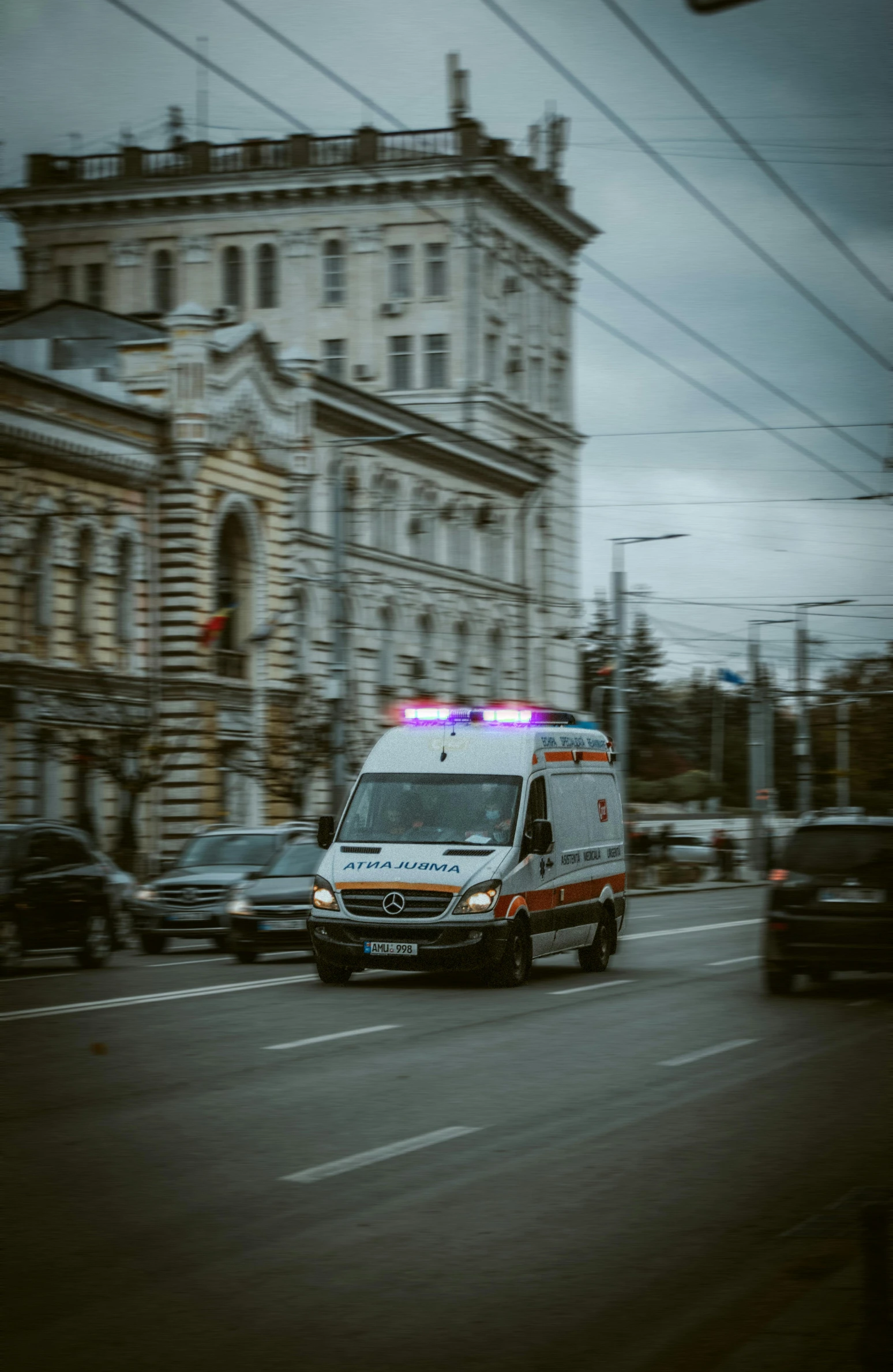 an ambulance with flashing lights traveling down the street