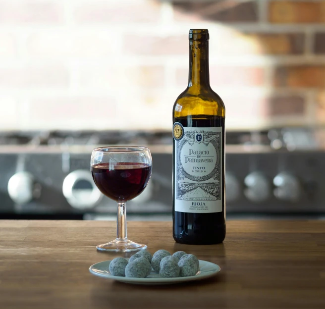 wine is next to a glass with a small stone next to it